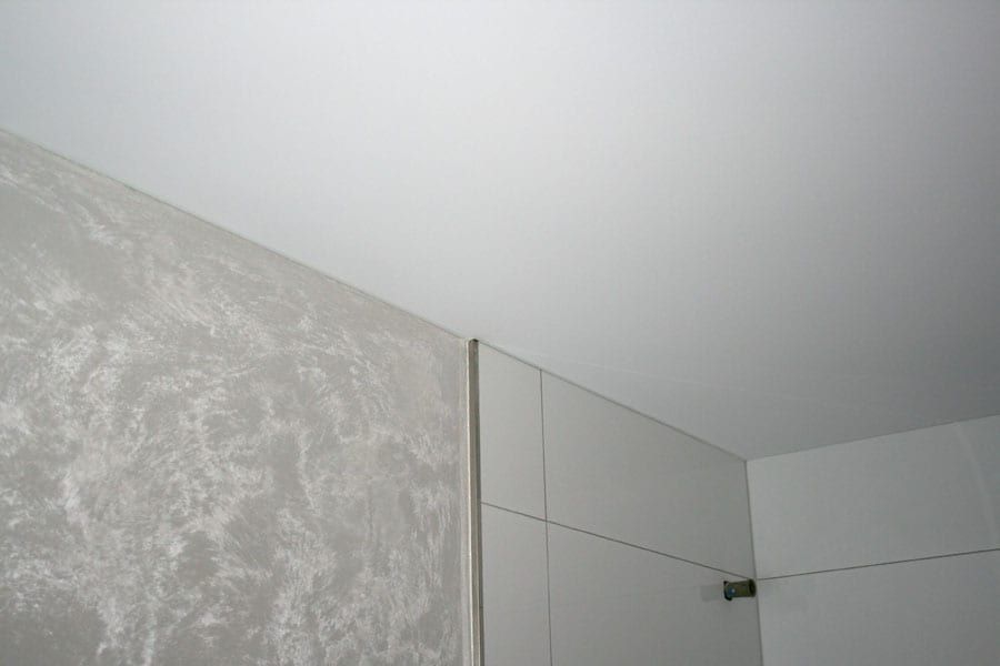 Badezimmergestaltung mit einer Spanndecke. Wände mit einer metallischen Lasur und Kristallzugabe veredelt