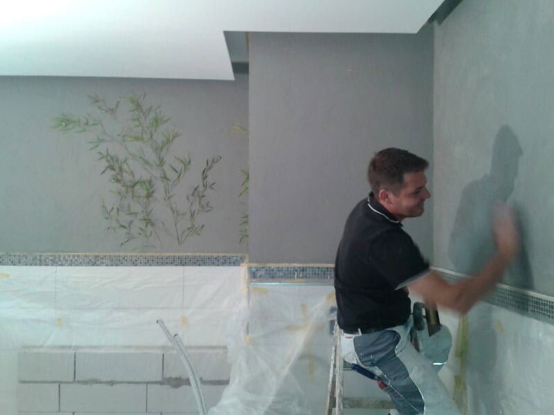Calce Colino im Badezimmer schwarz mit silber veredelt. Restliche Wände und Decke in weiß. Diffusionsoffen auf Kalkbasis. Einprägung von echtem Bambus in Calce Colino mit fossil versteinerter Wirkung.