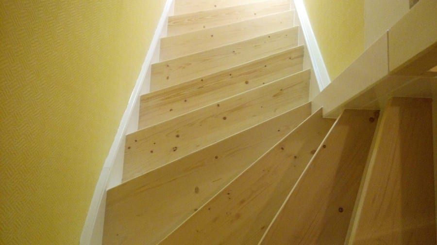Deckend lackierte Holztreppe abgeschliffen, Trittstufen farblos lackiert sowie Setzstufen und Wangen weiß lackiert
