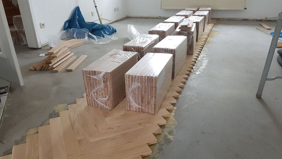 Eiche massiv Parkett, 22mm stark, im Fischgrat Verband verlegt und endbehandelt. Inkl. Fußleistenmontage.