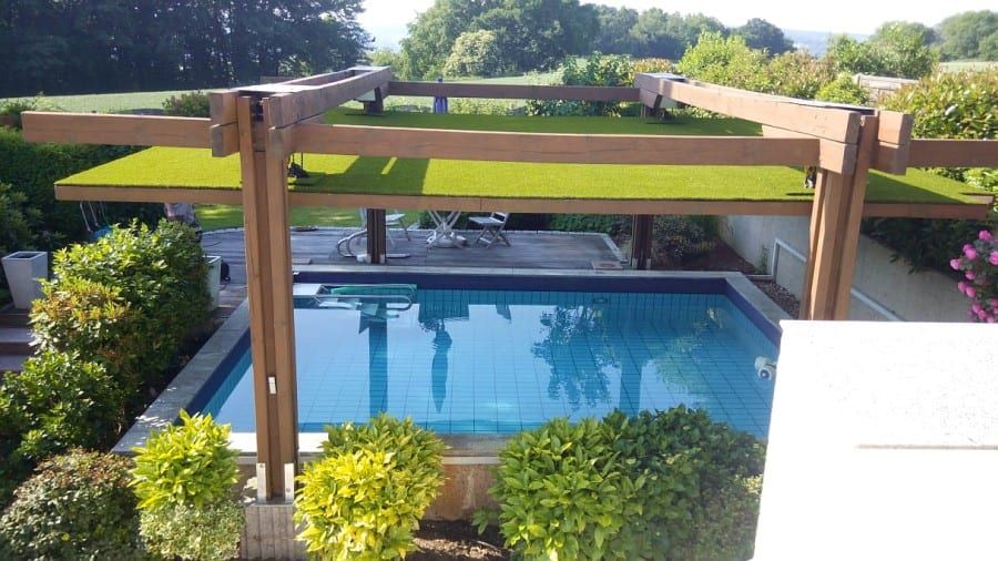 Poolbereich mit Holzpergola und angrenzender Gartenanlage