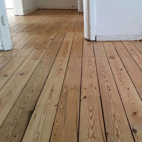 Verlegter Dielenboden aus hellem Echtholz in einem Wohnraum