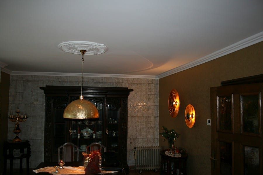 Wohn-, Eßzimmer mit Stuck an der Decke und einer Wandverkleidung aus handverarbeitetem Kork auf Goldlamee und mit goldfarbig bedrucktem Vlies aufgewertet