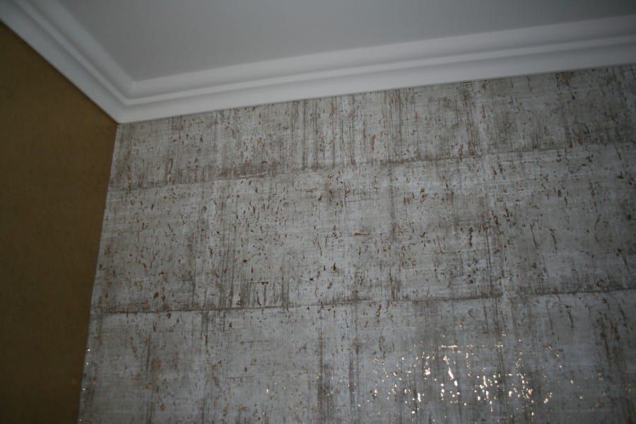 Wohn-, Eßzimmer mit Stuck an der Decke und einer Wandverkleidung aus handverarbeitetem Kork auf Goldlamee und mit goldfarbig bedrucktem Vlies aufgewertet