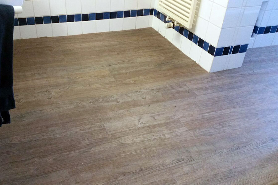Fertiggestellte Badezimmer-Bodenerneuerung mit modernem Vinylbelag.