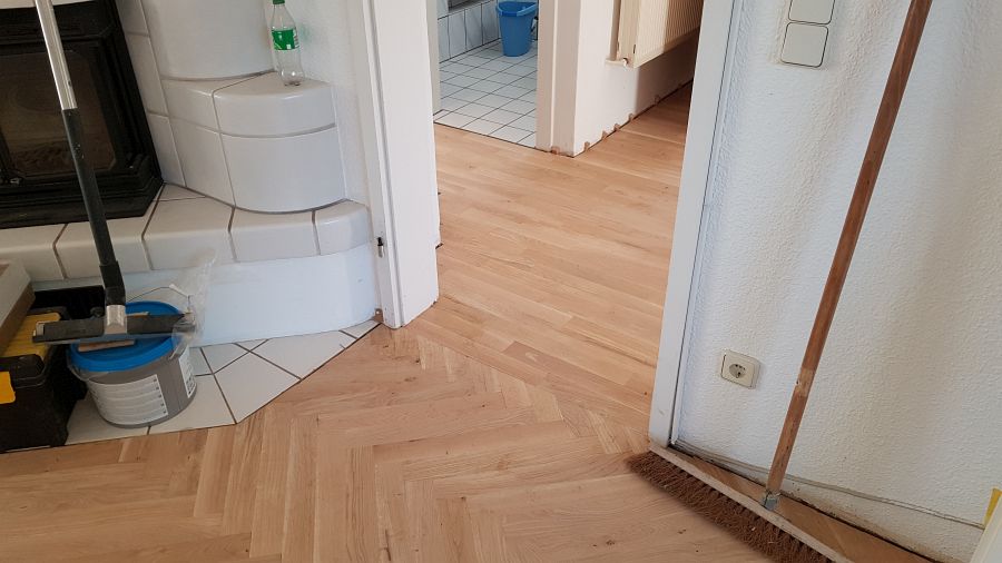 Eiche massiv Parkett, 22mm stark, im Fischgrat Verband verlegt und endbehandelt. Inkl. Fußleistenmontage.