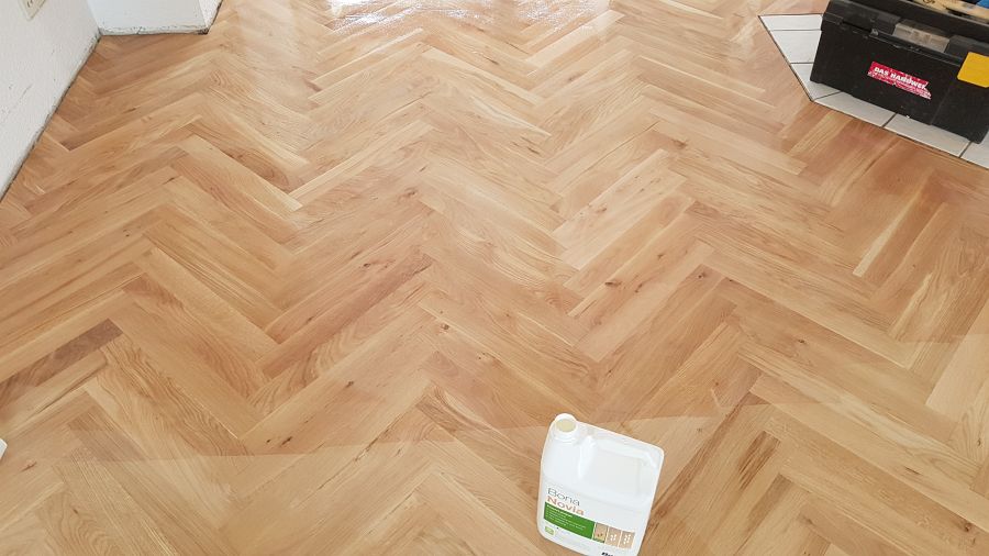 Eiche massiv Parkett, 22mm stark, im Fischgrat Verband verlegt und endbehandelt. Inkl. Fußleistenmontage.