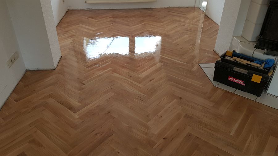 Eiche massiv Parkett, 22mm stark, im Fischgrat Verband verlegt und endbehandelt. Inkl. Fußleistenmontage.