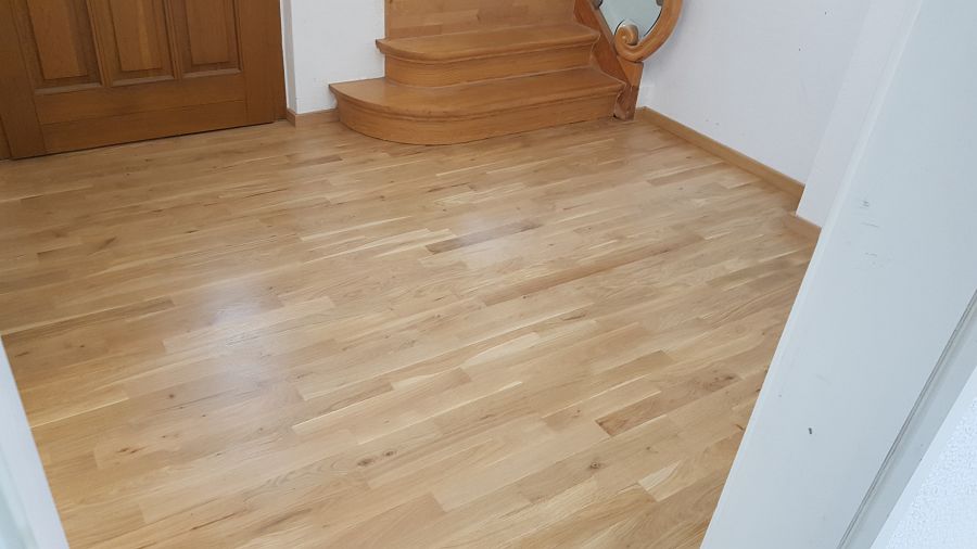 Eiche massiv Parkett, 22mm stark, im Fischgrat Verband verlegt und endbehandelt. Inkl. Fußleistenmontage.