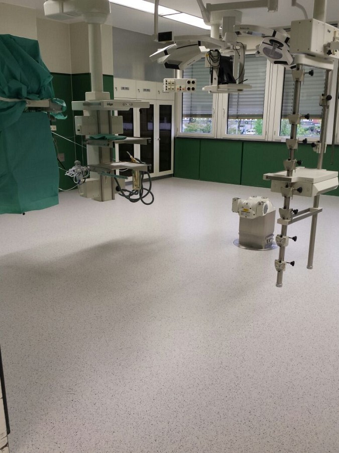 Präzise Verlegung des neuen, homogenen und leitfähigen PVC-Belags im OP-Saal.