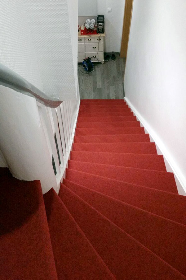 Historische Holztreppe mit königlich roten Textilbelag veredelt