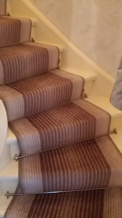 Treppenläufer auf einer Holztreppe verlegt und die gewendelten Stufen fachmännisch eingenäht