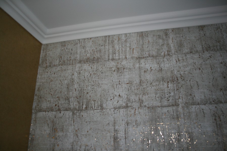 Wohn-, Eßzimmer mit Stuck an der Decke und einer Wandverkleidung aus handverarbeitetem Kork auf Goldlamee und mit goldfarbig bedrucktem Vlies aufgewertet